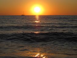mirror reflection of the evening sun in the sea in Italy