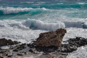 Colorful rocks on the beautiful seashore with waves in Ayia Napa, Cyprus, Greece, in sunlight