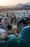 Beautiful landscape with the colorful buildings near the mountains, on the beach of the sea