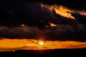 dark clouds over the forest at dusk