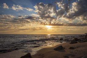 sunset in gray clouds over the coast