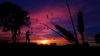 silhouette of a man near a tree on a background of a purple sky during sunset