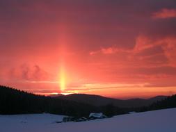 sun beam bursting through clouds at winter Sunset