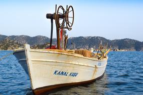fishing boat in the sea with mountains in the background