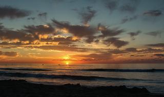 sun in the clouds on the horizon over the coast