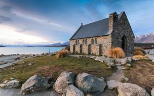 Beautiful and colorful landscape with the home, among the plants and rocks, on the shore of the river