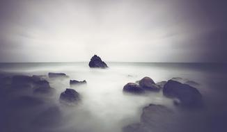 rocks near the seashore in the fog