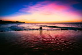silhouette of a couple in love near the sea at sunset time