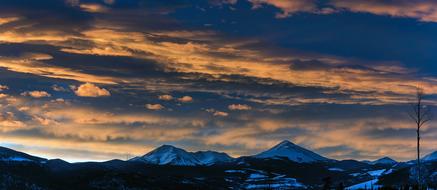 clouds over snow-capped mountains during sunset