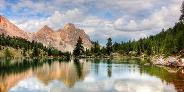 Beautiful landscape of the lake, among the green trees and rocks, on the Dolomites in South Tyrol, Italy