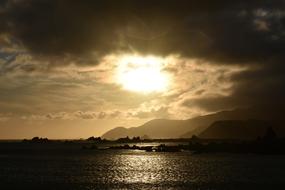 dark clouds over the sea and mountains at dusk