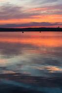 Beautiful lake with the silhouettes of fishermen, at colorful and beautiful sunset, among the clouds