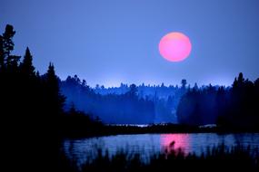 Beautiful landscape of the lake among the trees, in fog, in Quebec, Canada, at colorful and beautiful sunset
