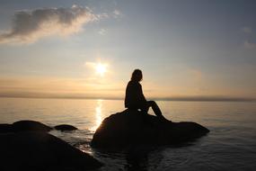 silhouette of a man on a coastal stone