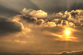 Beautiful and colorful Sun, among the clouds in the sky