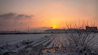 sunrise in the clouds over the countryside in winter