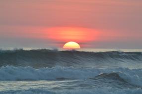 ocean waves at colorful sunset close up