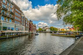 boats on the canal near buildings in amsterdam