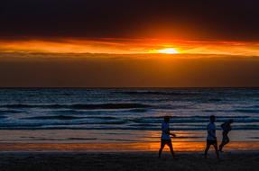 people on the ocean coast at colorful twilight