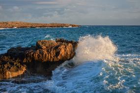 spray on the sea coast at sunset
