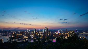 Bird's eye view of the city among the water, with colorful lights, at colorful and beautiful sunset with clouds