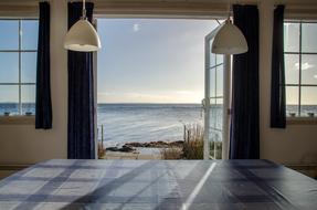 Beautiful view of the sea with the beach with colorful plants, from the cottage