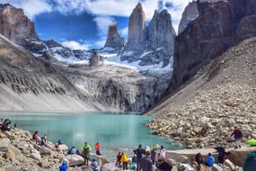 People on the rocks, near the beautiful lake and snowy mountains in Patagonia