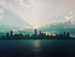 Coast of Chicago, USA, with buildings, at background with sunlight in the clouds