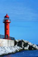 lighthouse with red walls by the sea
