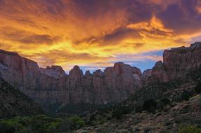 Beautiful landscape of the mountains with plants, under the colorful and beautiful clouds at sunset