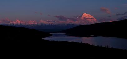 distant view of snow-capped mountains in alaska at dusk