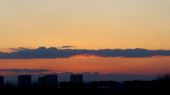 silhouettes of city buildings against the sky during sunset