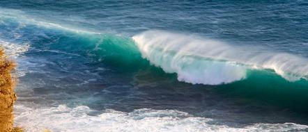 Close-up of the beautiful and colorful, gradient wave on the beach, in sunshine