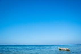 white rowing boat anchored on blue Sea