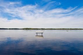 bench in the middle of a blue lake