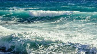 Close-up of the beautiful and colorful waves in sunlight, on the rocky shore of Ayia Napa, Cyprus, Greece