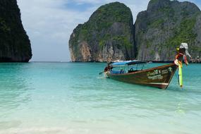 Colorful boat on the beautiful and colorful, sandy beach of Phi Phi, Thailand, among the mountains
