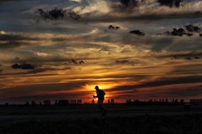 running man silhouette at dramatic Sunset Sky