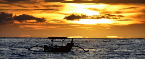 Silhouette of the boat on the water in Philippine, at orange sunset among the clouds