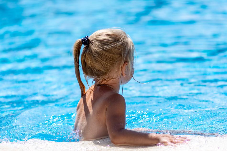 blonde baby in the water on a sunny day