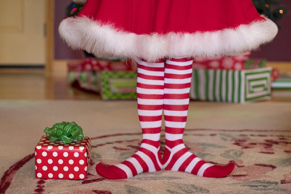 Beautiful and colorful Elf legs and a Christmas present on the floor