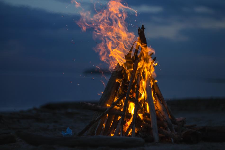 Beautiful campfire with flames, on the shore, in the evening