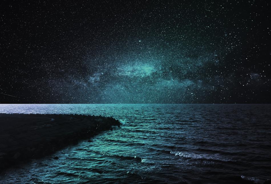 the ocean under the starry sky at night