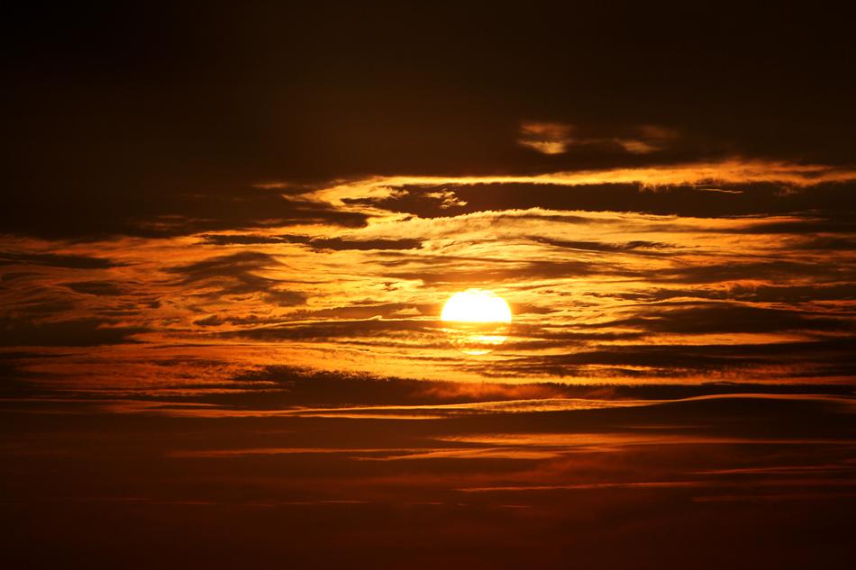 Beautiful and colorful sunset with the Sun, among the clouds in the sky