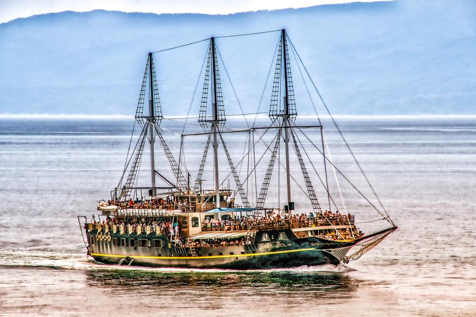 Colorful ship on the beautiful waterscape with waves, at blue sky on background
