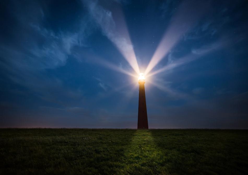 lighthouse with bright rays at dusk