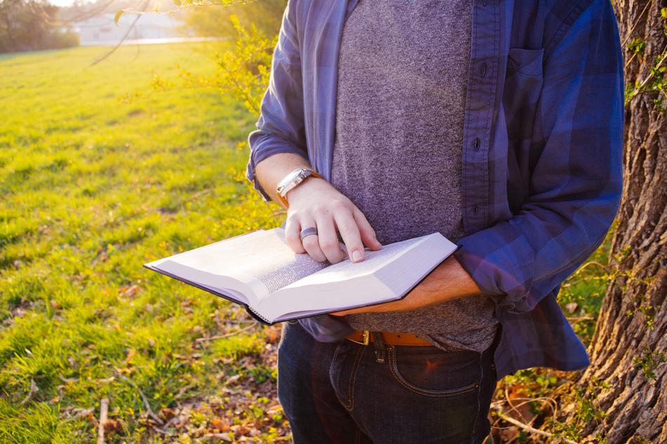 guy with a book near a tree close-up
