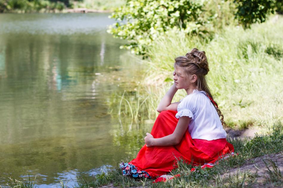 beautiful girl looking at the pond