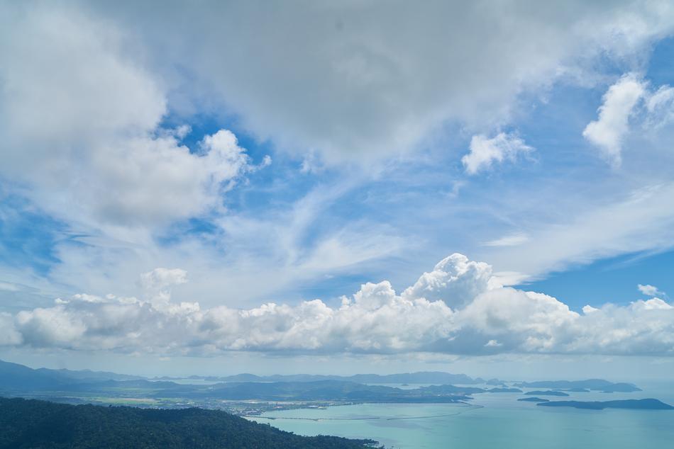white clouds in the sky over the sea