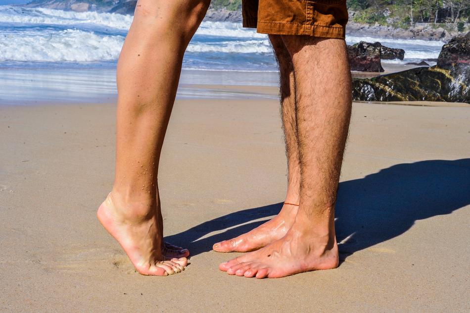 photo of couple feet on the beach